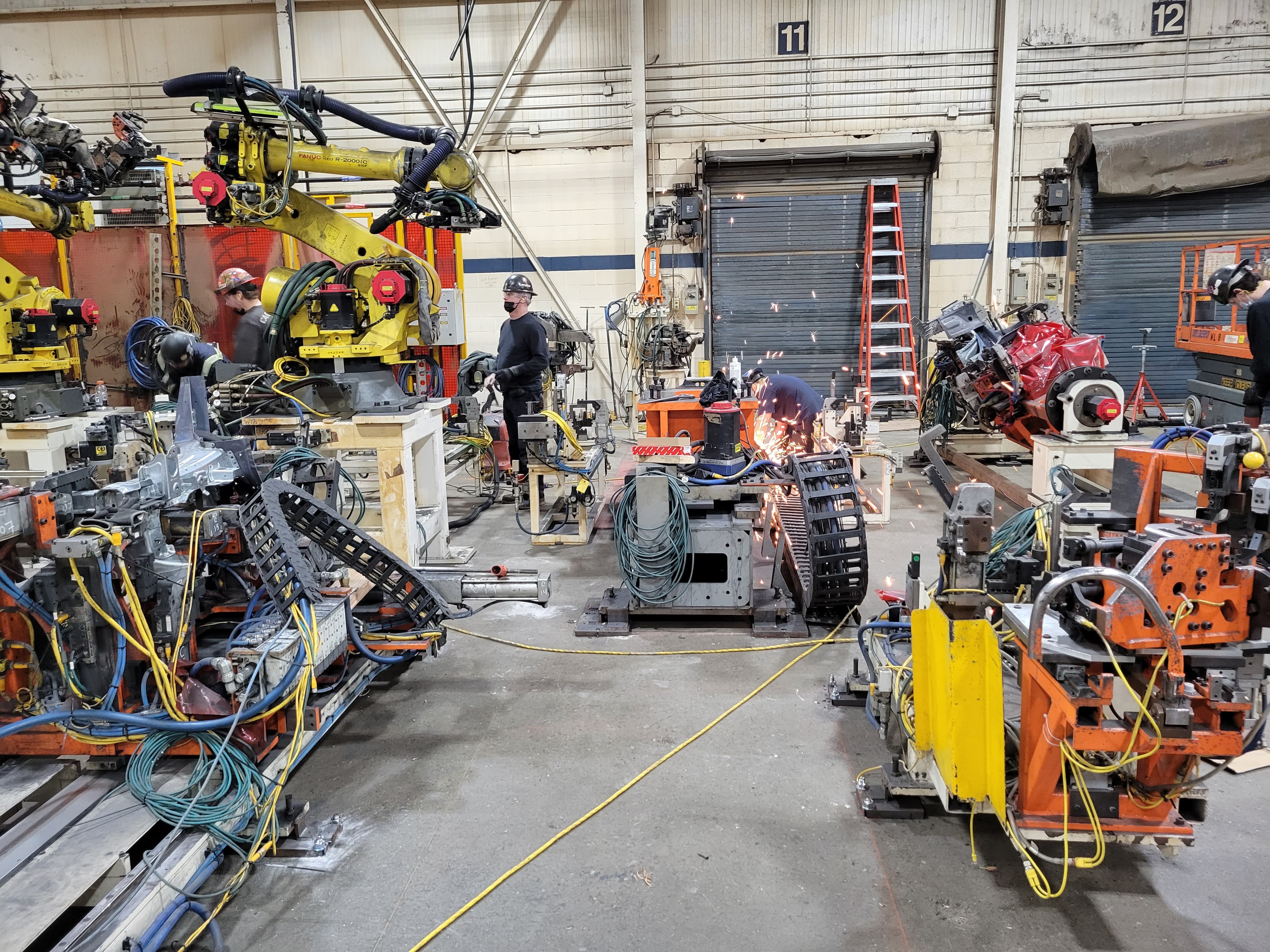 Robot weld cell installation in progress with welding sparks