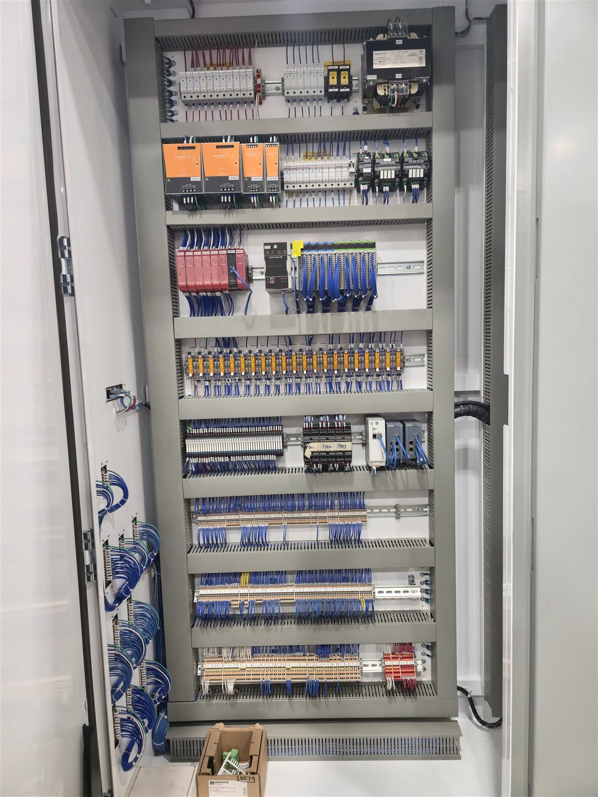 Large multi-bay production control panel with eight organized wiring columns