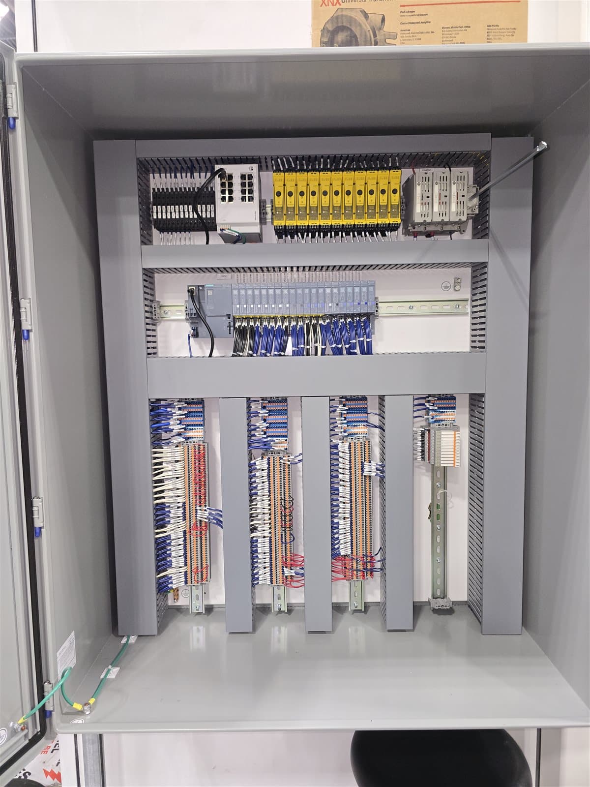 Tall vertical control panel with safety relay bank and dense terminal block wiring