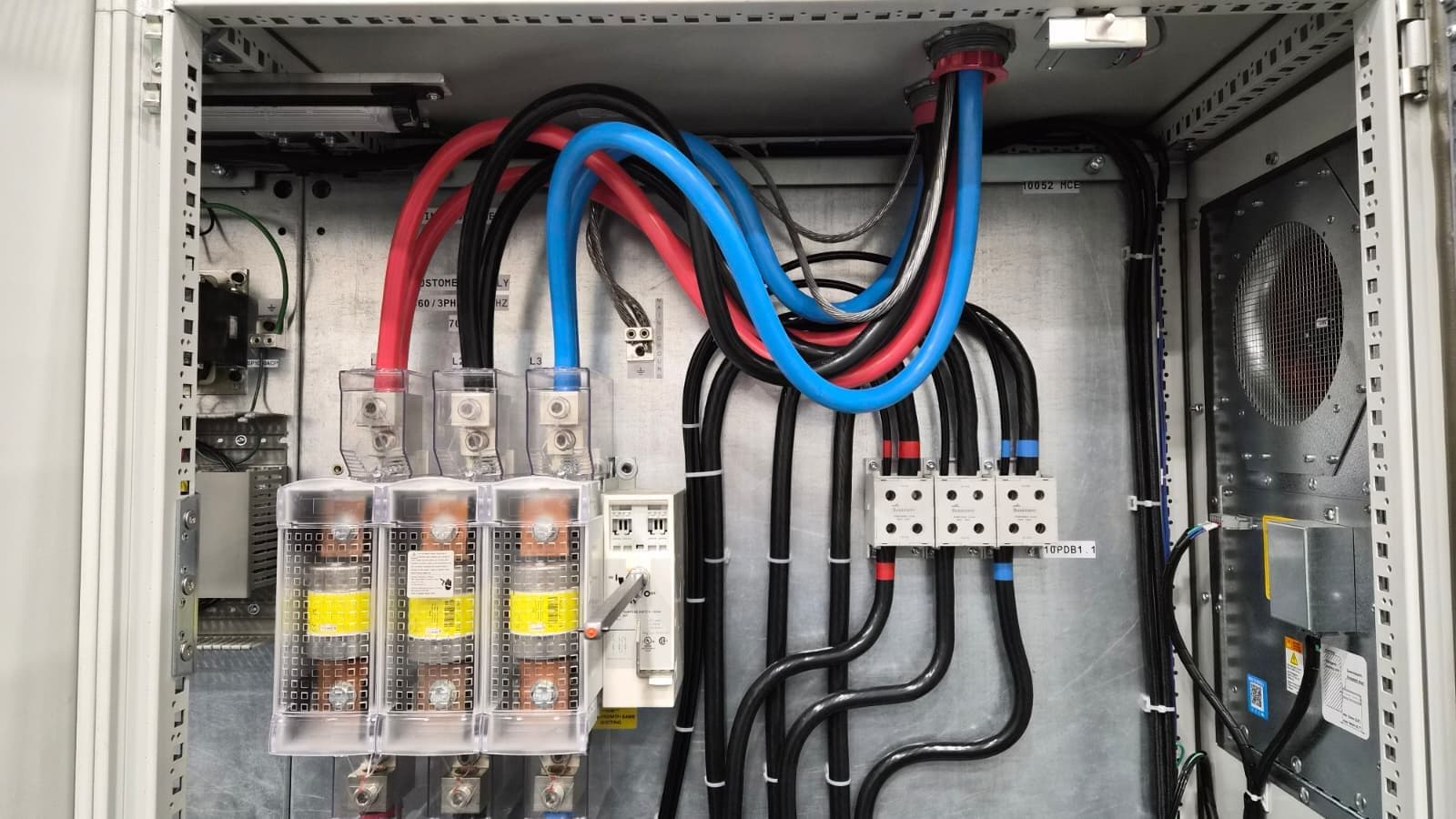 Color-coded power feeders wired into disconnect switches and a distribution block