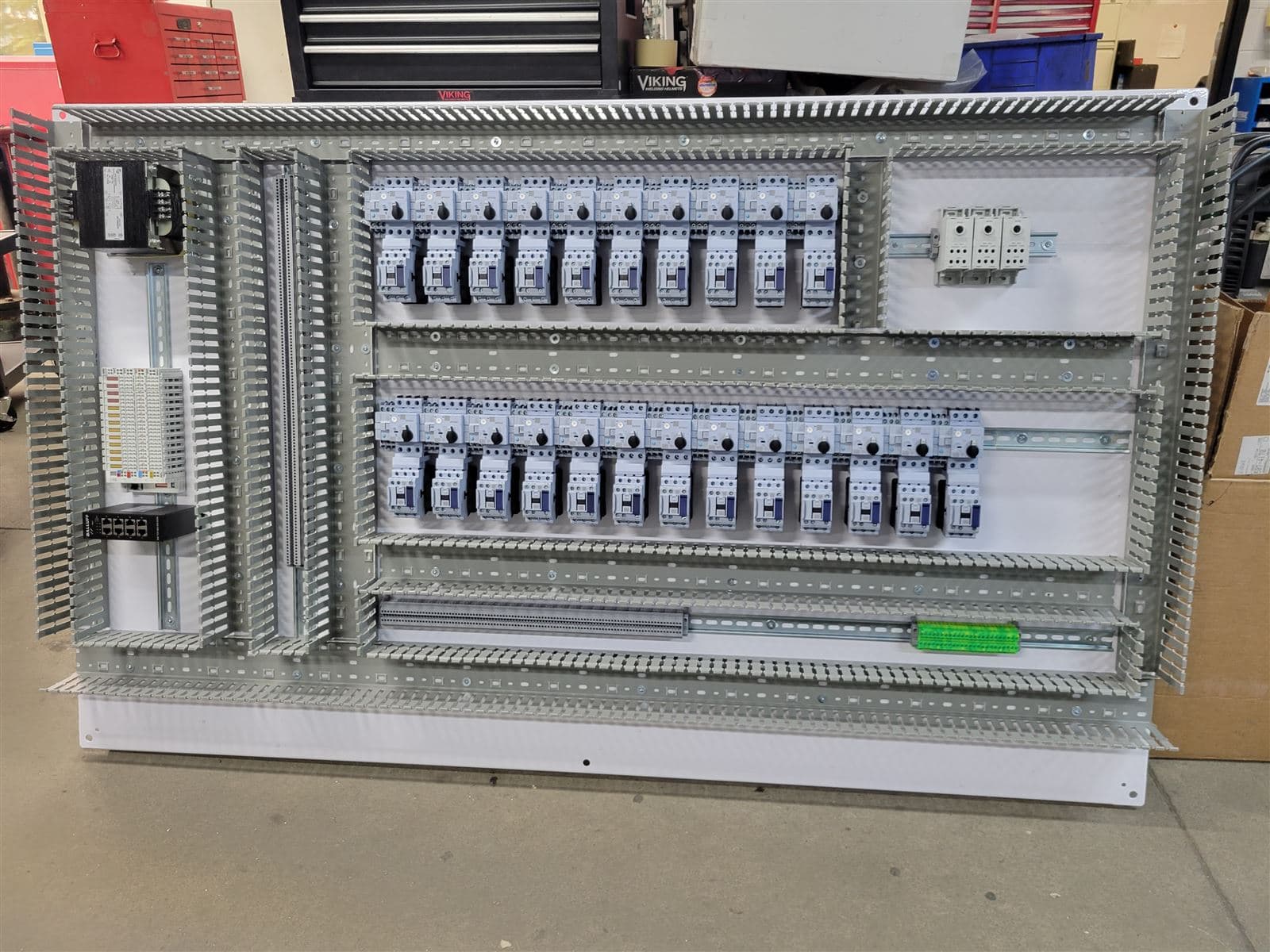 PLC control panel interior with dual DIN rail layout and labeled wiring