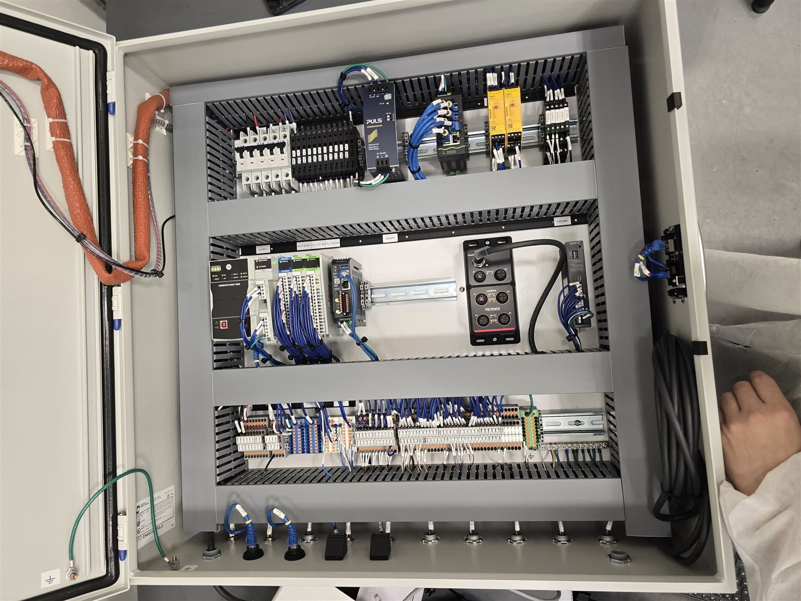 Three-tier control panel with PLC, servo drive, and HMI keypad