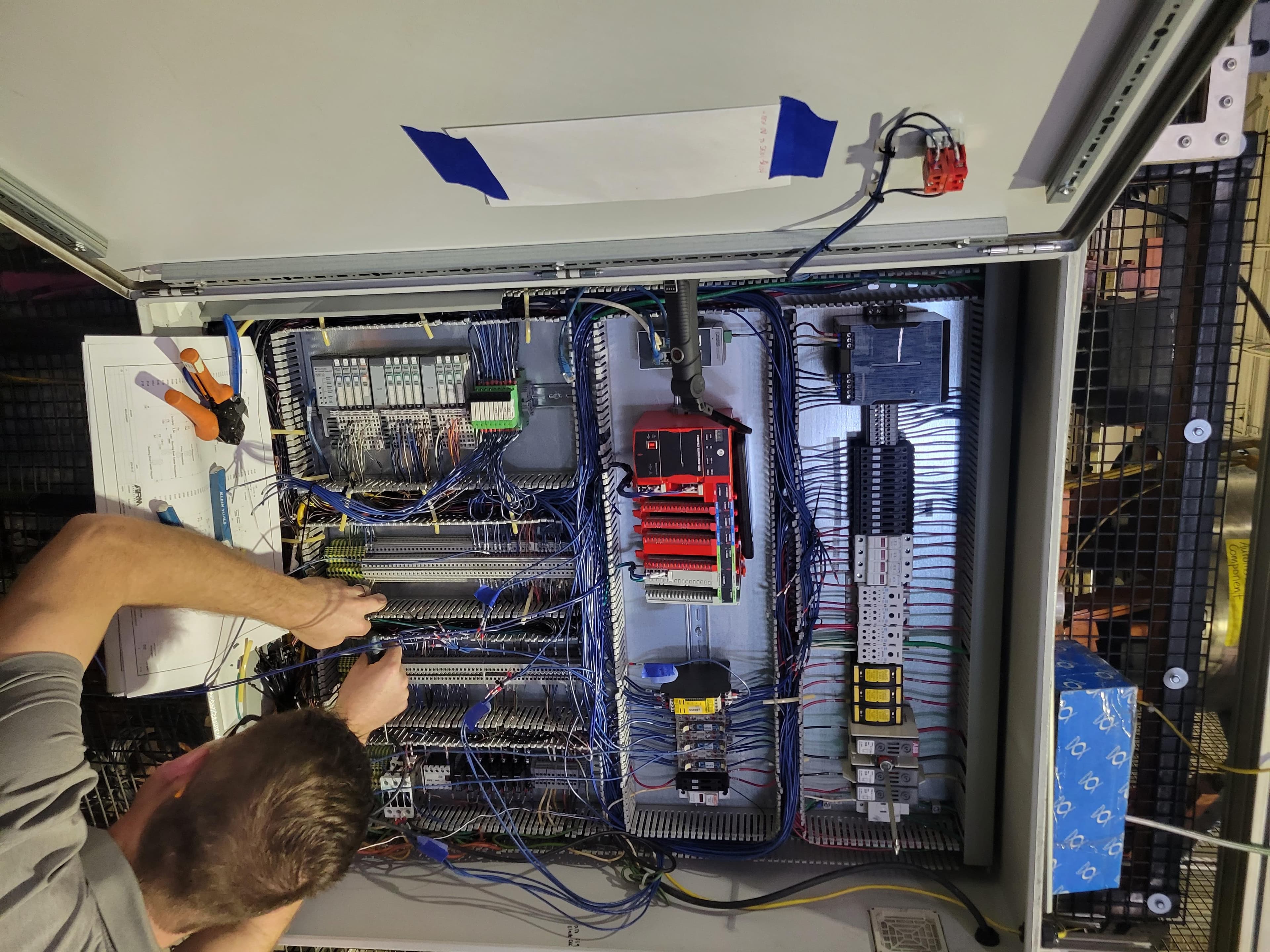 Technician rewiring a control panel during a retrofit upgrade